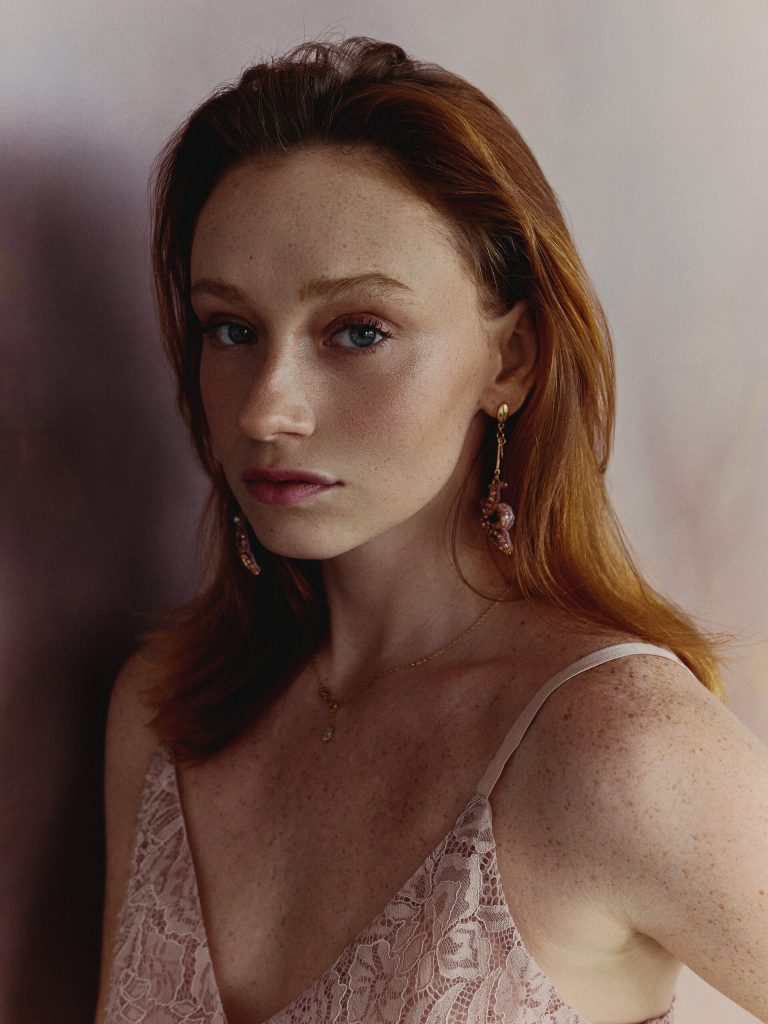 Portret rudowłosej modelki z piegami i kolczykiem, miękkie światło
